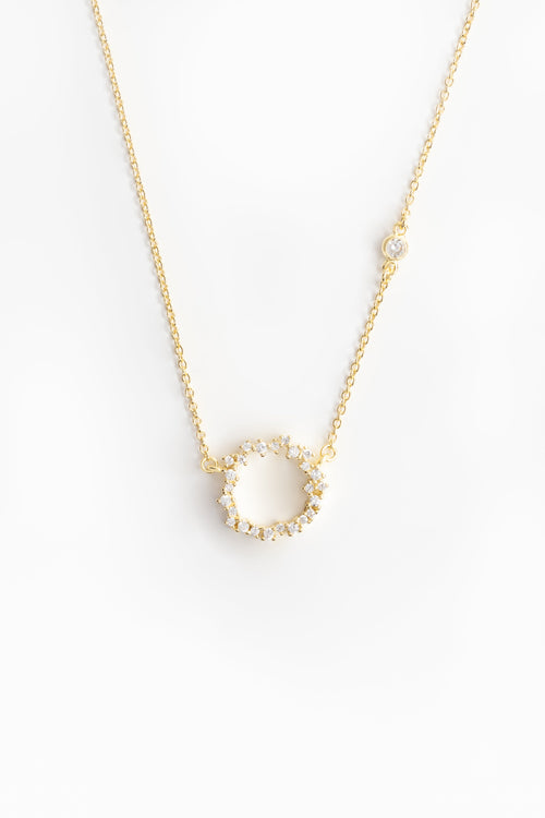 cubic zirconia encrusted gold pendant on a gold chain with a small diamond on a link of the chain